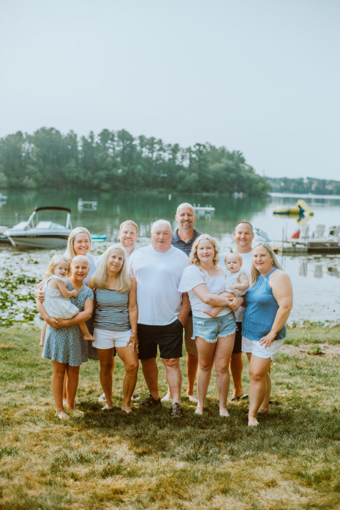 Three generations standing in front of Sunset Lake during their extended family session.