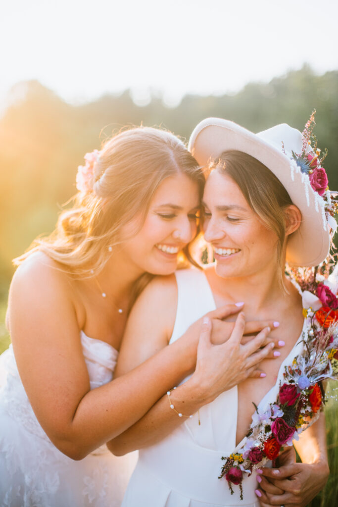 Brides smiling at each other in their bridal style from Miss Ruby Boutique during a disco garden styled shoot at Green Bay Botanical Gardens in Green Bay, WI.
