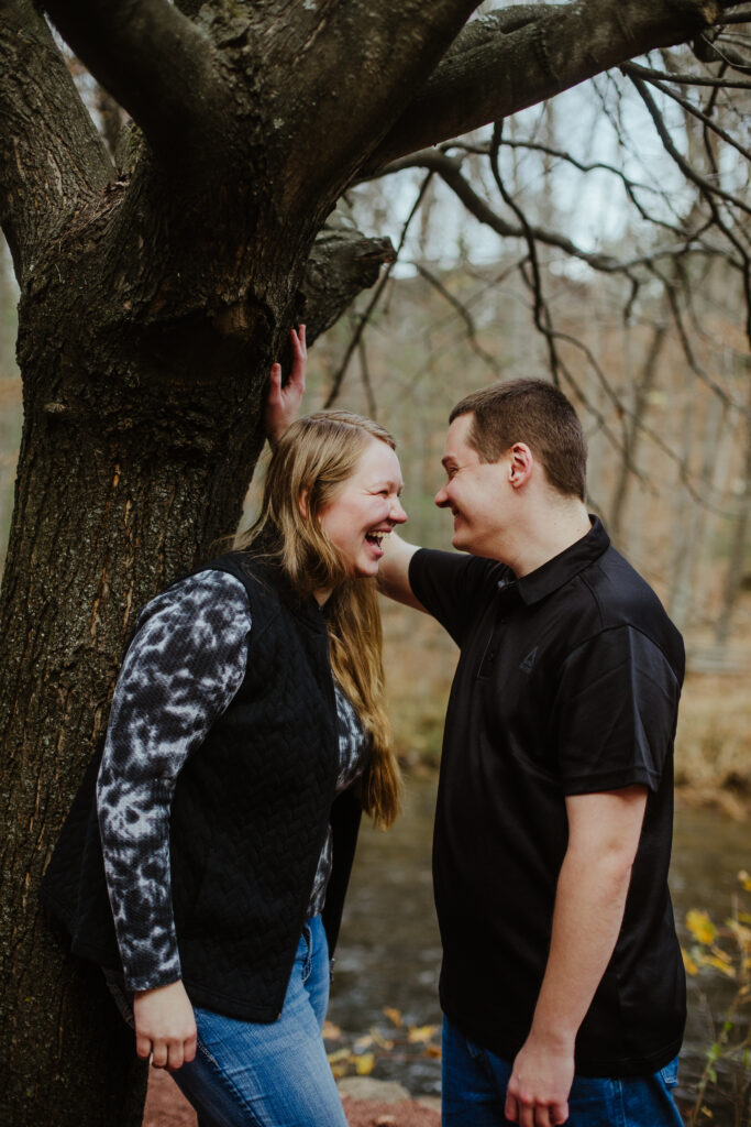 Couple laughing at each other during their engagement session at Red Mill in Waupaca, WI.