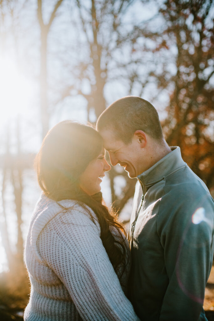Couple snuggling close during their engagement session at Jorgens Park Preserve in Scandinavia, WI.
