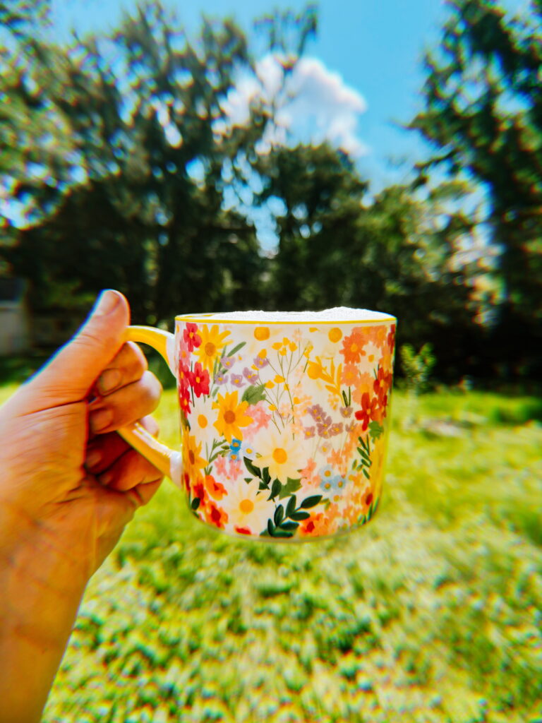 Currently: drinking coffee in the backyard on a sunny morning out of a Dollar General mug covered in bright wildflowers