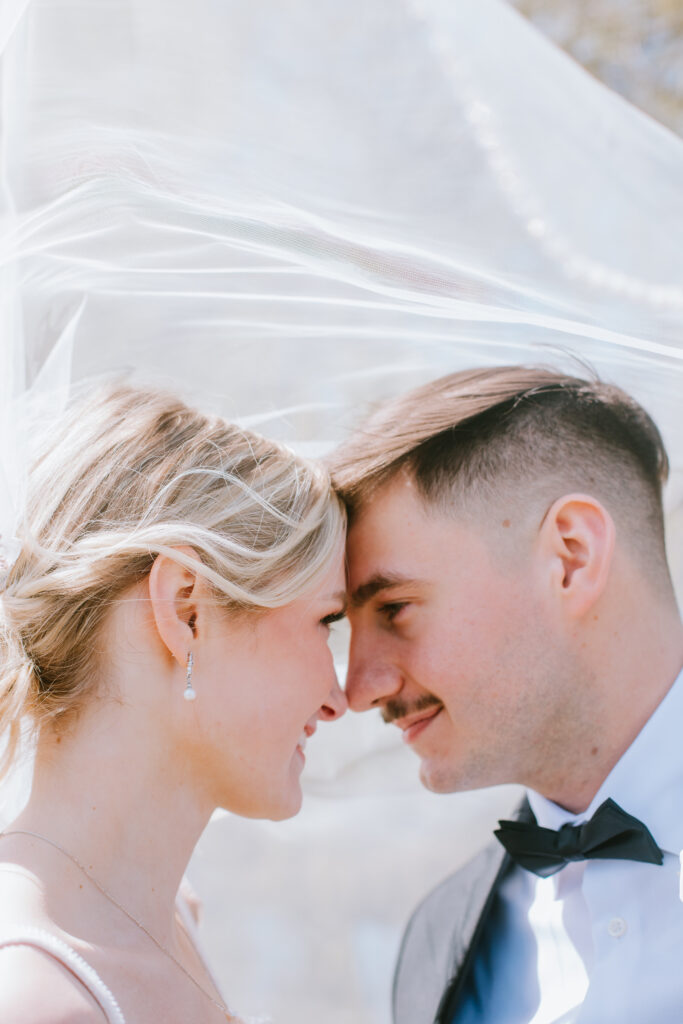 Bride and groom getting cozy and staring into each other's eyes after their private ceremony during their Lakeshore Pavilion wedding day.